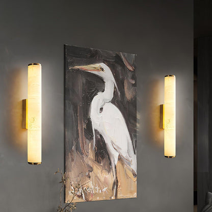 Wandleuchte mit Marmorschirm und messingfarbener Halterung an einer dunklen Wand neben einem Gemälde