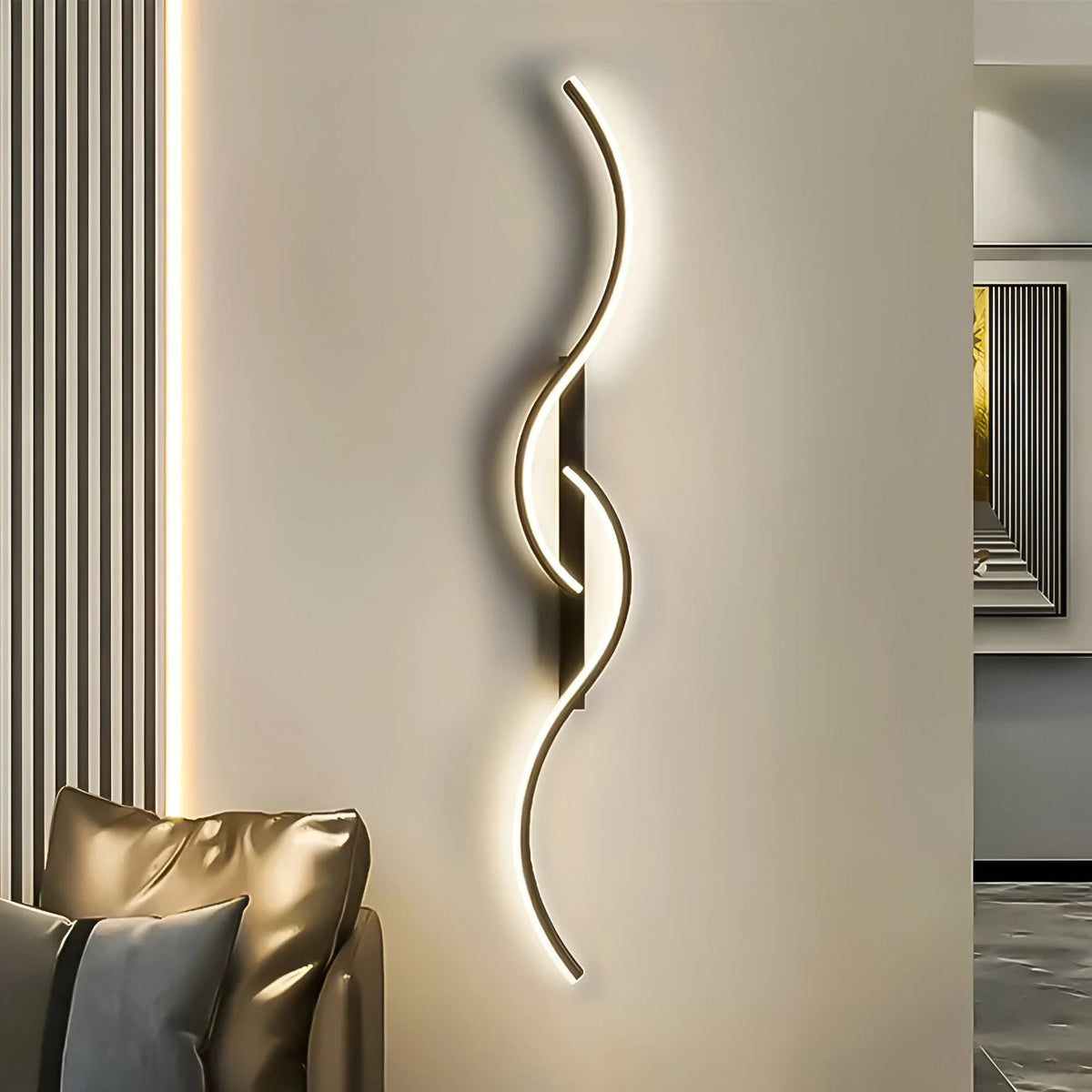 Schwarze Wellenlampe leuchtet an heller Wand neben einem Sofa mit grauem Kissen 4