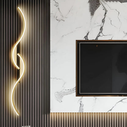 Goldfarbene Wellenlampe an dunkler Lamellenwand neben einem Fernseher vor weißer Marmorwand 3