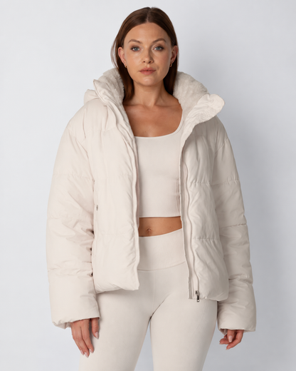 Model trägt die offene cremeweiße Steppjacke mit Fleecekragen zu hellem Crop-Top und Leggings, Frontansicht 1