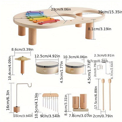 Maßzeichnung mit allen Einzelteilen des Sets: Tischplatte mit Beinen, Becken, zwei Trommeln, Klangspiel, Rasselwalzen, Schlägel und Schrauben samt Abmessungen. 