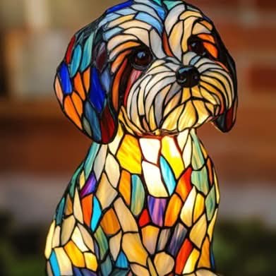 Nahaufnahme einer kleinen zotteligen Hundefigur im Buntglas-Stil mit bunten Schlappohren