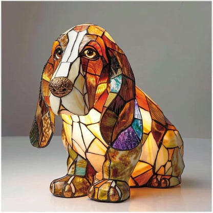 Sitzende Basset-ähnliche Hundefigur im Mosaikstil mit langen Schlappohren, warm leuchtendem Bauch und glänzenden Pfoten