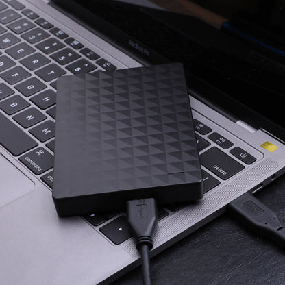 Dieselbe Festplatte auf der Laptoptastatur, per USB-Kabel angeschlossen, in der Arbeitssituation am Notebook 3