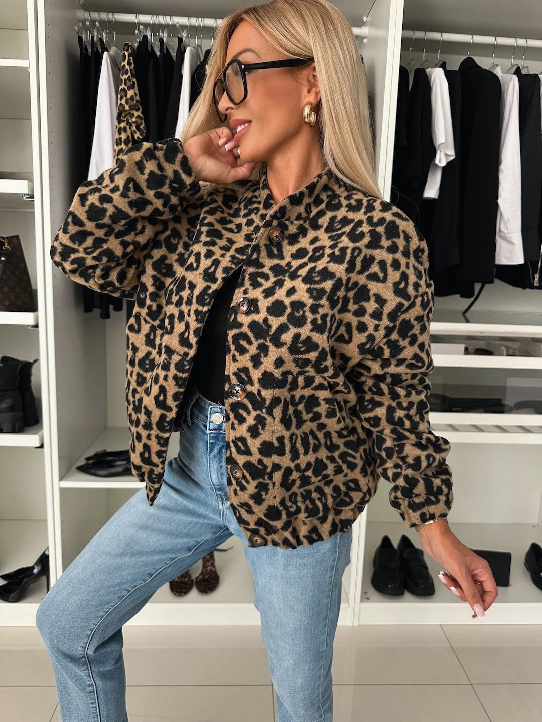 Leopardenprint-Jacke in Schwarz und Braun offen über einem schwarzen Top und Jeans, Seitenansicht.