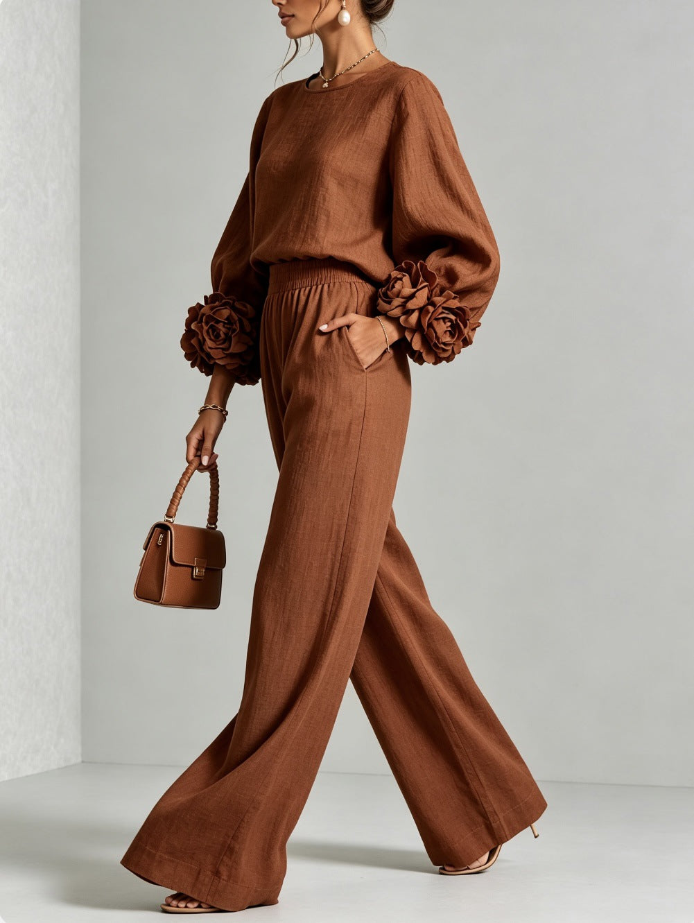Rostbraunes Set mit Blütenmanschetten und passender Handtasche, vom Model im Profil beim Gehen getragen 5