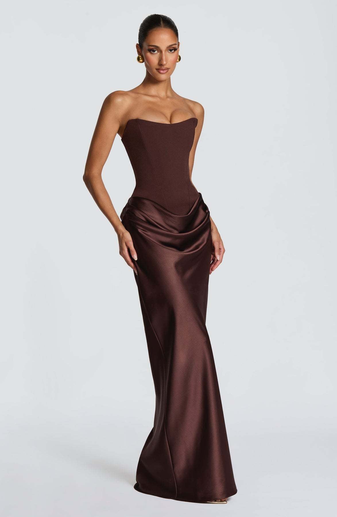 Dunkelbraunes Korsettkleid im Dreiviertelwinkel, Model mit Hand am Rock, glänzender Satin mit Drapierung 12