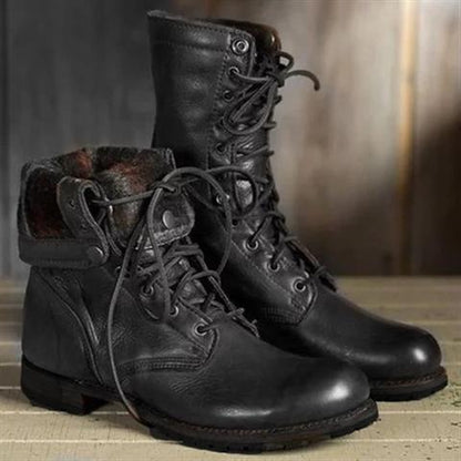 Schwarze Leder-Schnürstiefel, einer mit umgeschlagenem, kariert gefüttertem Schaft, in Seitenansicht.