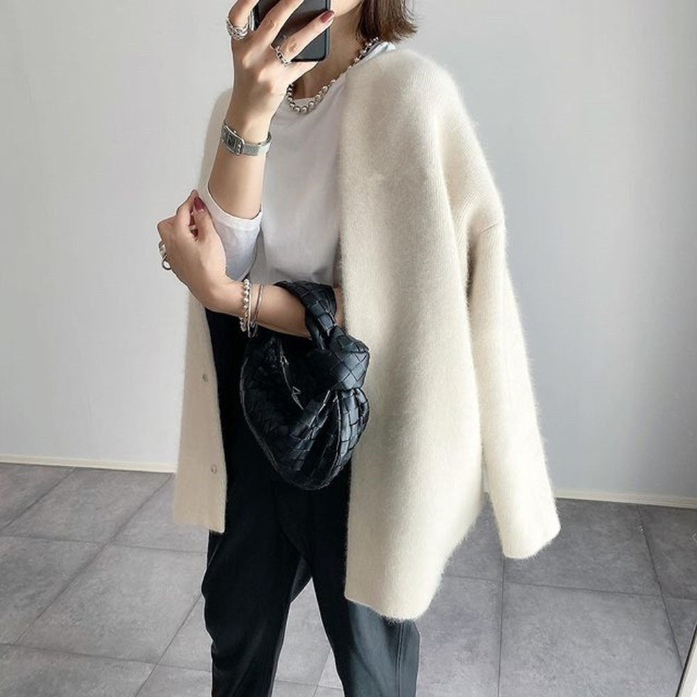 Cremeweißer Cardigan offen getragen, seitlich fotografiert, mit weißem Shirt, schwarzer Hose und kleiner schwarzer Tasche 3