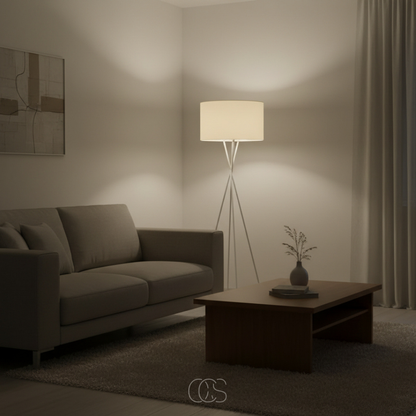 Eingeschaltete weiße Stehlampe wirft abends weiches Licht in eine Zimmerecke neben Sofa und Holzcouchtisch 8