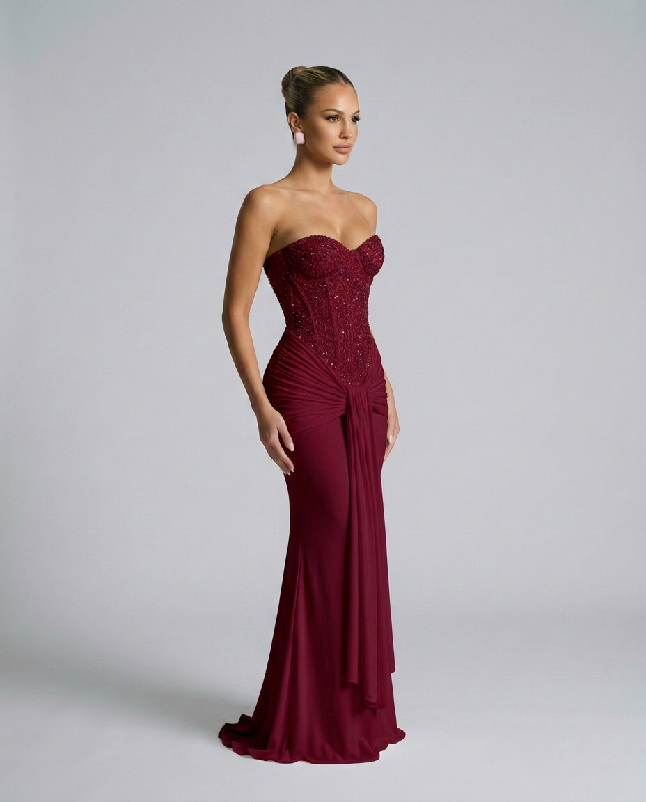Weinrotes Kleid mit funkelnder Korsage in seitlicher Dreiviertelansicht, die Drapierung fällt an der Hüfte herab 4