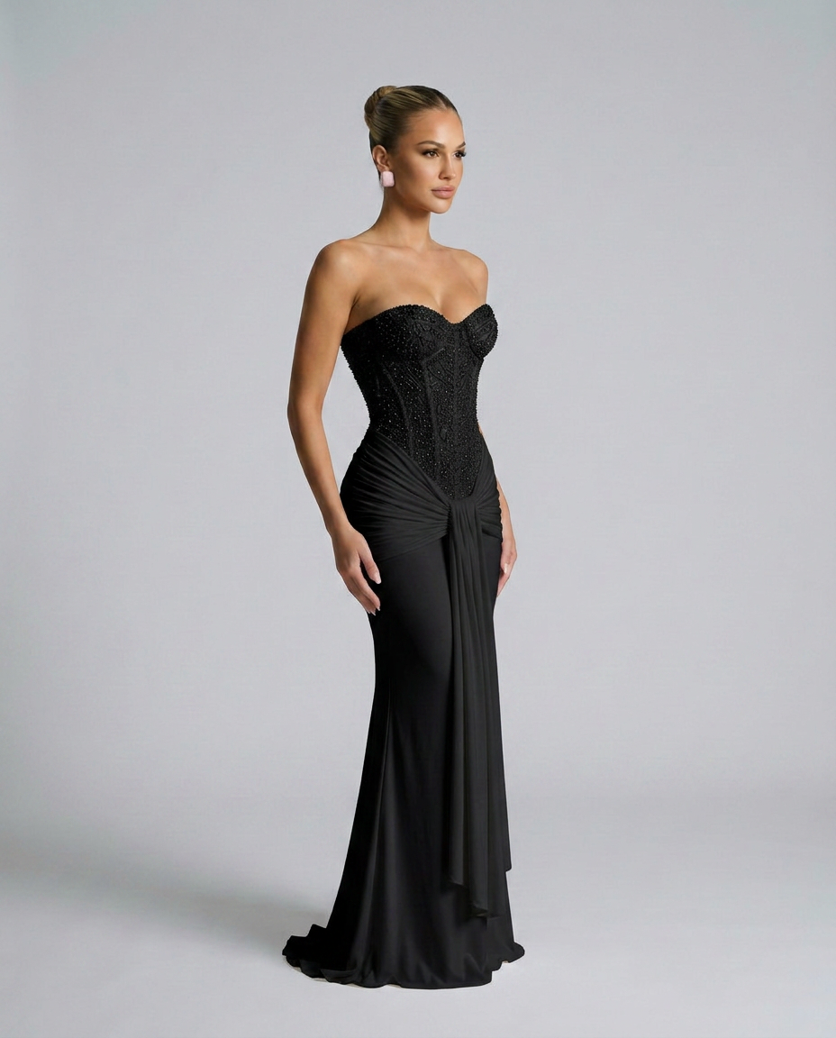 Schwarzes Kleid mit Korsage und Drapierung in seitlicher Dreiviertelansicht am Model, Schleppe am Saum sichtbar 2
