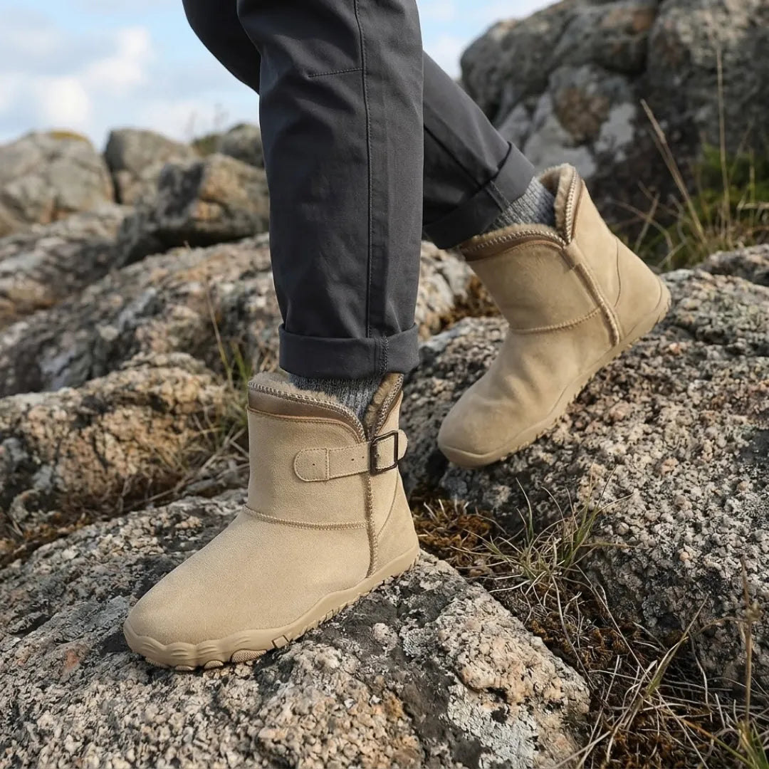 Beige Stiefel mit Fellfutter, getragen mit grauen Socken beim Gehen auf felsigem Gelände 2