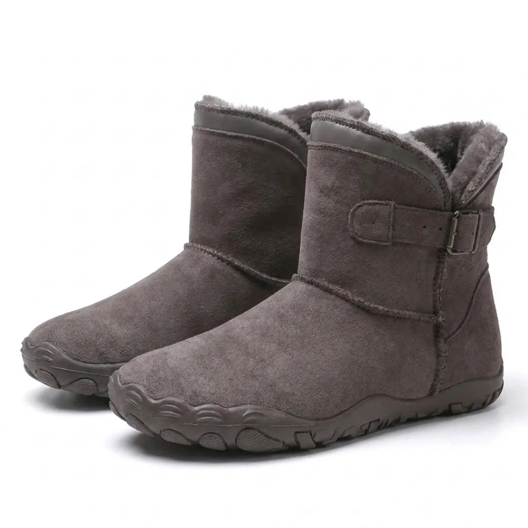Paar graubrauner Stiefel mit Plüschfutter, Schnallenriemen und breiter Profilsohle in schräger Seitenansicht 43