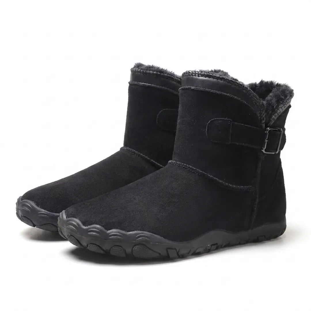 Paar schwarze Stiefel mit Fellfutter und Schnalle, schräg von vorne fotografiert 16