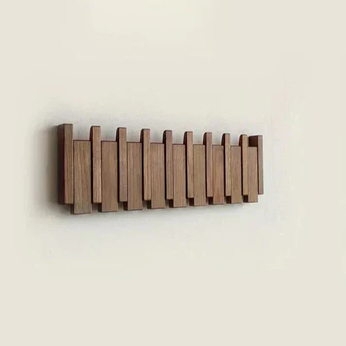 Piano Massivholz-Garderobe aus dunklem Holz mit eingeklappten Haken und Klaviertasten-Design
