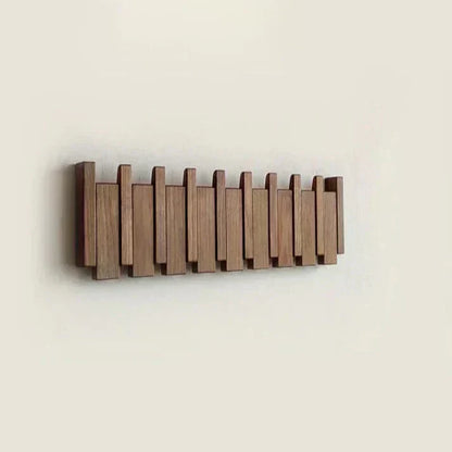 Piano Massivholz-Garderobe aus dunklem Holz mit eingeklappten Haken und Klaviertasten-Design