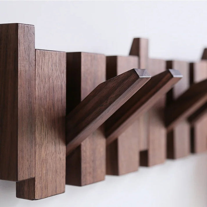 Piano Massivholz-Garderobe aus dunklem Holz mit mehreren ausgeklappten Haken, Detail