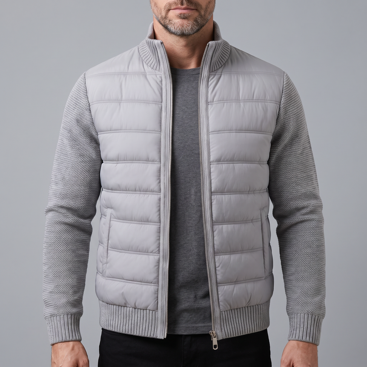 Mann trägt die hellgraue Steppjacke mit Strickärmeln offen über einem dunkelgrauen T-Shirt, Frontansicht 1