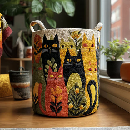 Runder Wäschekorb mit bunten gesteppten Katzen und Blumen, mit zwei Stoffgriffen, auf einem Holzboden vor dem Fenster zwischen Zimmerpflanzen. 1