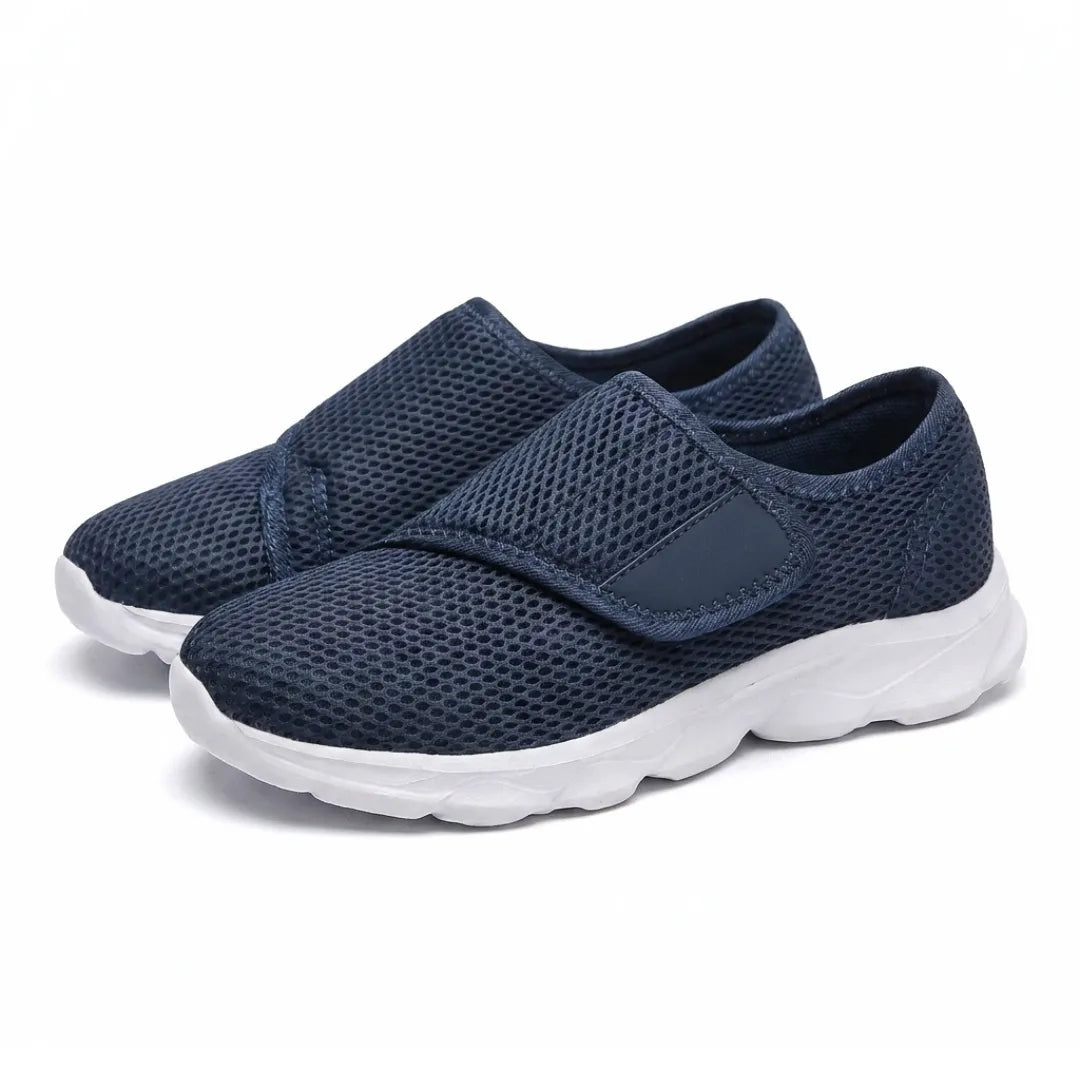 Paar marineblaue Netz-Schuhe mit Klettverschluss und weißer Sohle, leicht schräg von vorn auf weißem Hintergrund. 7