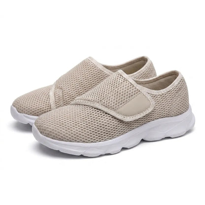 Paar beige Netzschuhe mit Klettverschluss und weißer, gedämpfter Sohle, schräg von vorne auf weißem Hintergrund fotografiert. 34