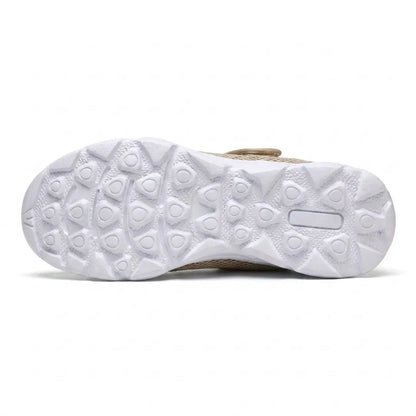Unterseite der weißen Sohle mit Profil aus dreieckigen und runden Noppen für Halt und Rutschfestigkeit, am Rand der beige Schuh sichtbar. 36