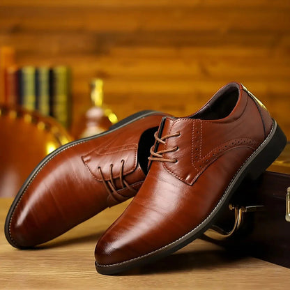 Herrenschuhe mit geschlossener Schnürung in Braun mit Brogue-Lochmuster, schräg auf einem Holztisch