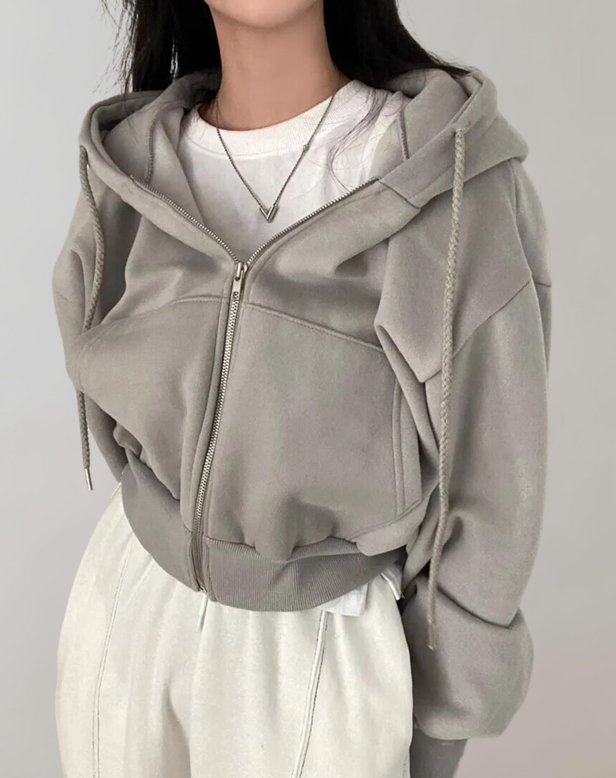 Taubengrauer kurzer Zip-Hoodie mit Kordelzugkapuze und Rippbündchen am Saum.