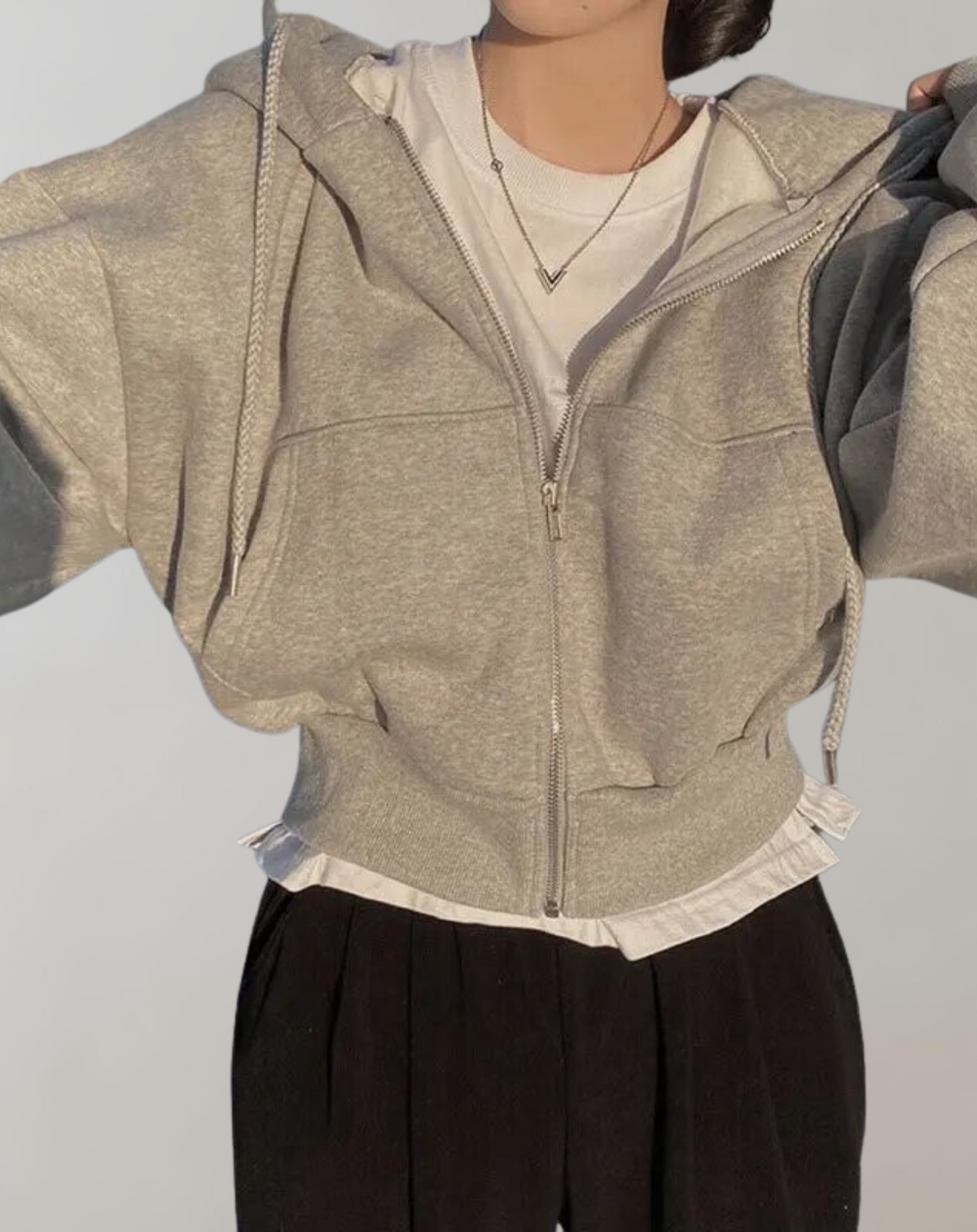 Grau melierter Hoodie mit Reißverschluss und Rippbündchen.