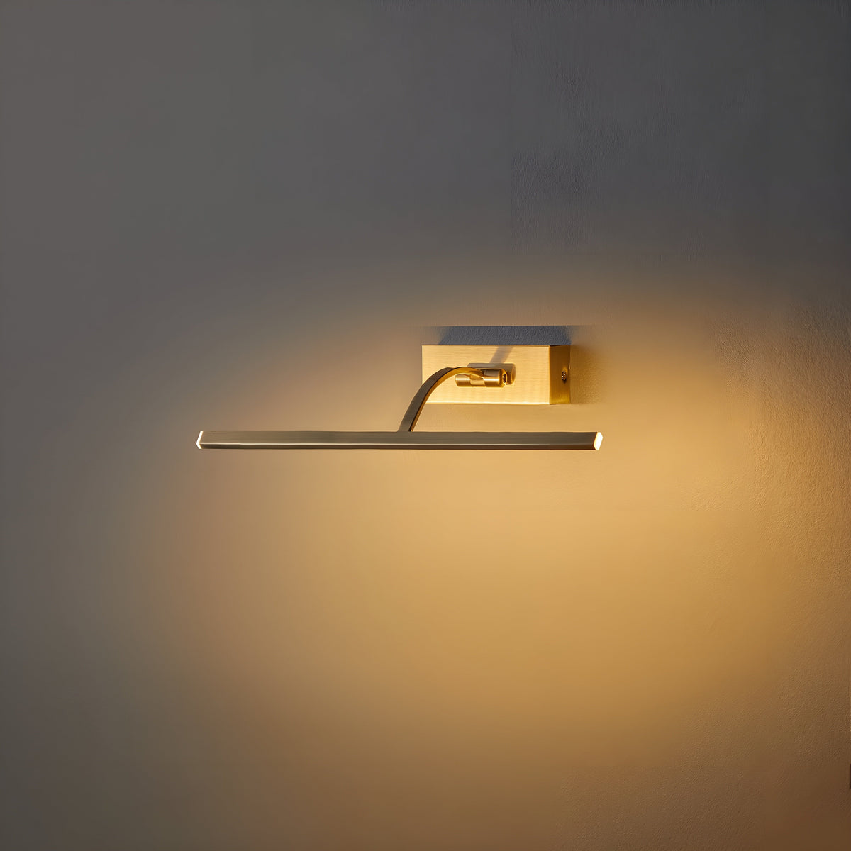 Schräg angewinkelte Bildleuchte an der Wand, der gebogene Arm taucht die Wand in warmes Licht 3