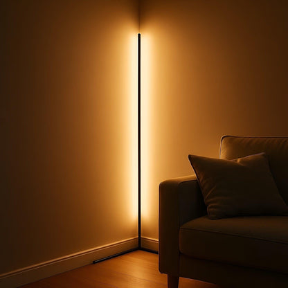 Schwarze LED-Eck-Stehlampe leuchtet kräftig warm in der Zimmerecke neben einem Sofa mit Kissen auf Holzboden. 7
