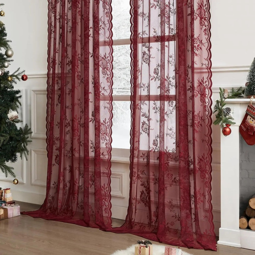 Zwei weinrote durchsichtige Vorhangpaneele mit Blumenmuster vor einem Fenster, weihnachtlich dekorierter Raum mit Tannenbaum und Kamin. 2