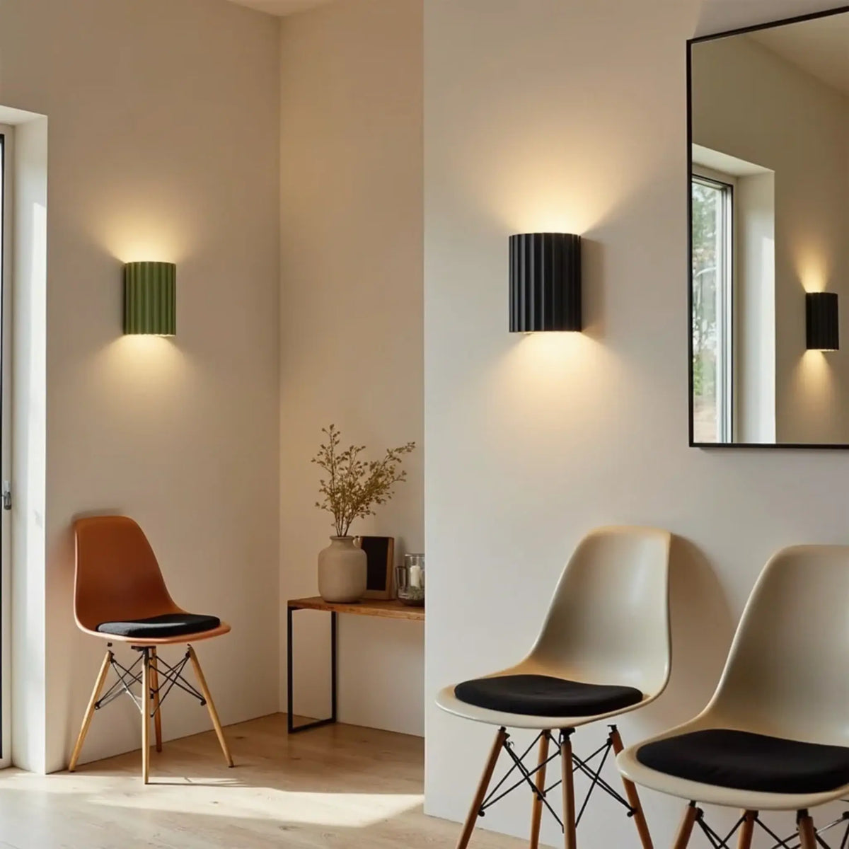 Eine grüne und eine schwarze gerillte Wandlampe in hellem Raum mit Stühlen, Konsole und Spiegel 3