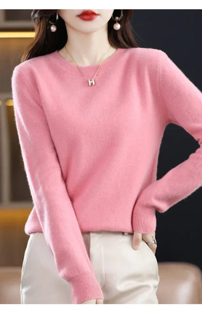 Rosa Pullover mit Rundhals, Hand in die Hüfte gestützt, dazu eine cremefarbene Hose 8