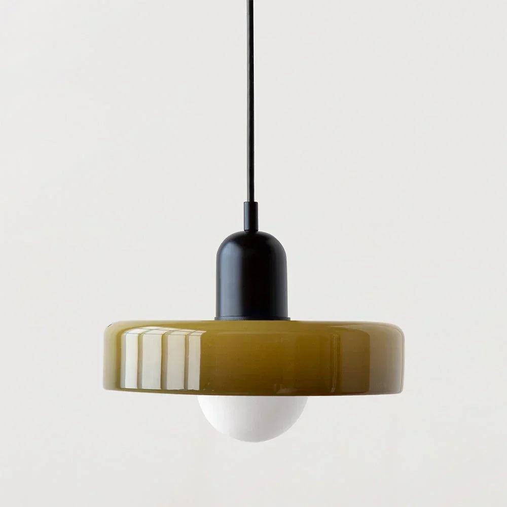 Pendelleuchte mit olivfarbenem Glasschirm, schwarzer Kappe und schwarzem Kabel, darunter eine matte weiße Kugellampe. 23