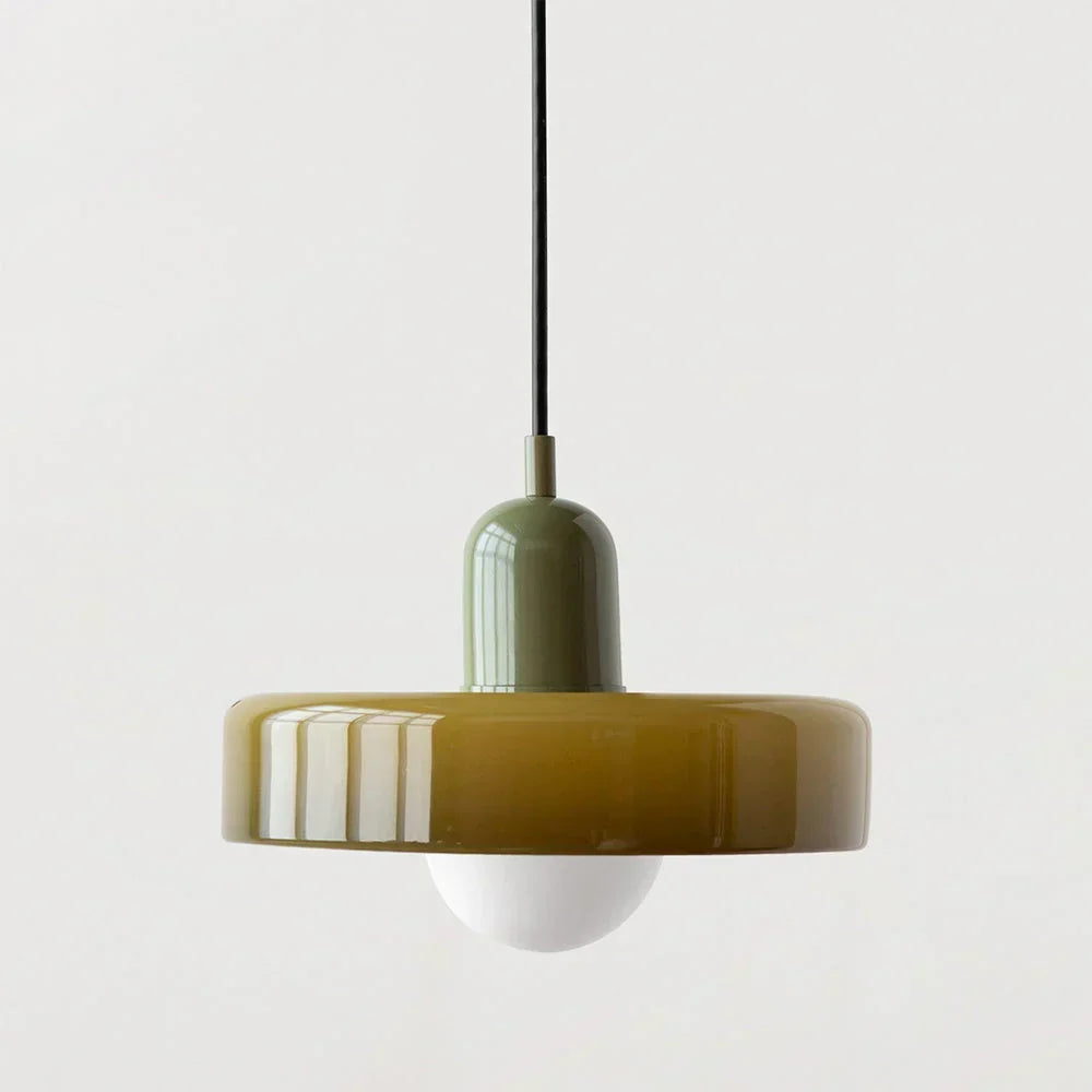 Pendelleuchte mit olivgelbem Glasschirm, graugrüner Metallkappe und schwarzem Kabel vor neutralem Hintergrund. 22