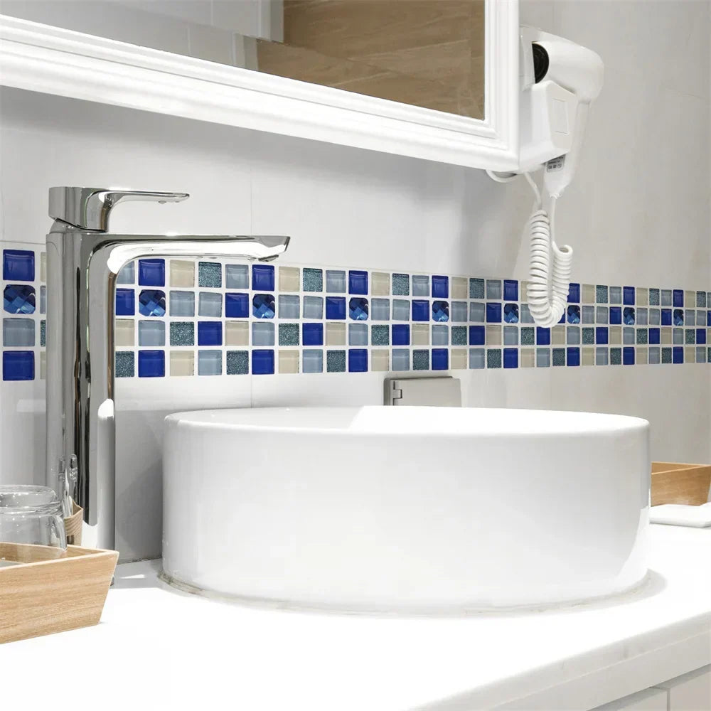 Badezimmer mit Mosaikstreifen in Blau-, Beige- und Grautönen oberhalb eines runden Waschbeckens mit Armatur 56