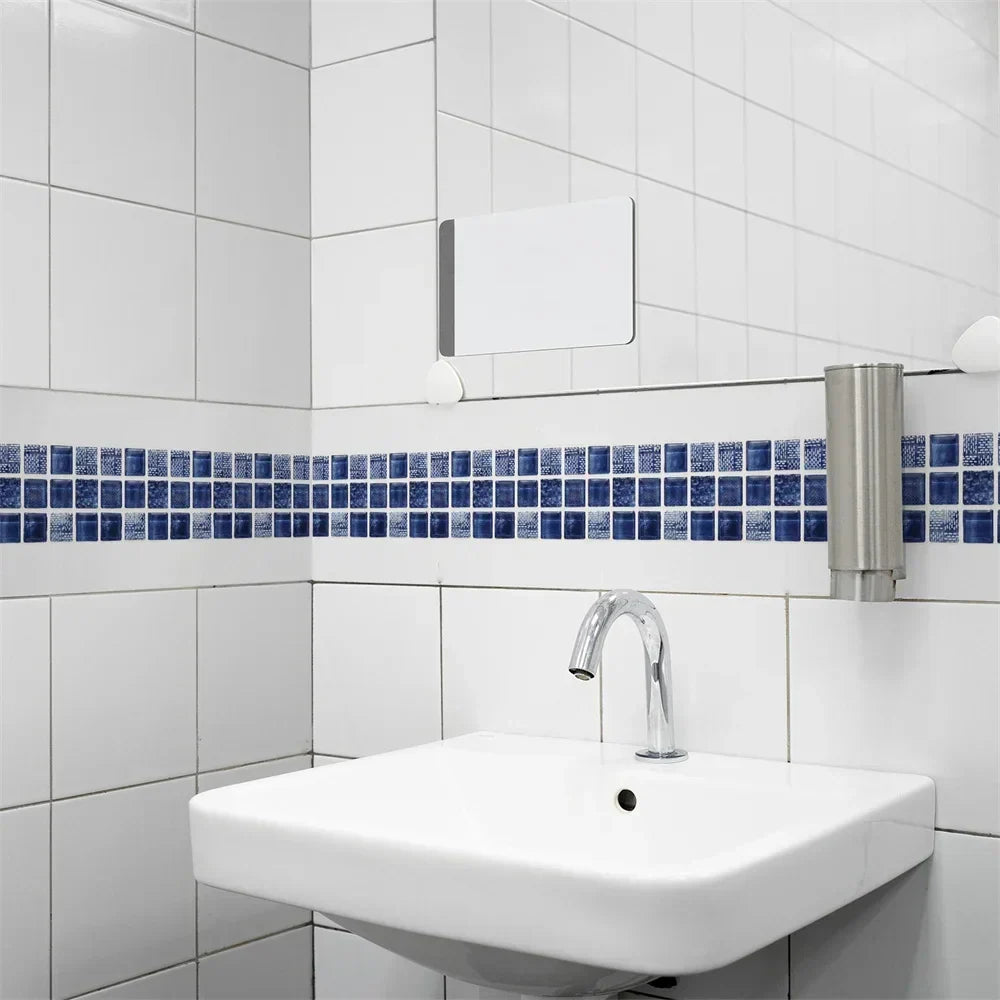 Blaue Mosaikbordüre an weißen Badezimmerfliesen über einem Wandwaschbecken mit Chrom-Armatur 15