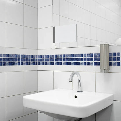 Blaue Mosaikbordüre an weißen Badezimmerfliesen über einem Wandwaschbecken mit Chrom-Armatur 15