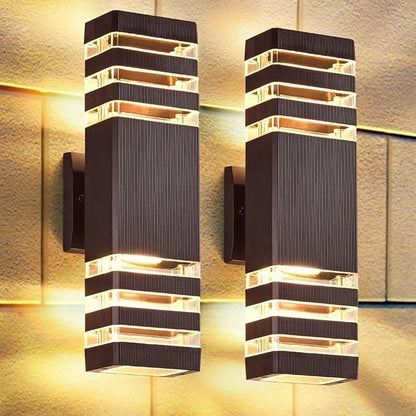 Schwarze Außen-LED-Wandlampe mit geriffeltem Gehäuse und Up- und Downlight-Effekt an einer Steinwand.