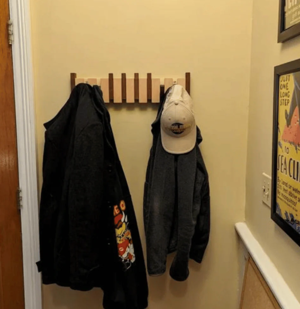 Piano Massivholz-Garderobe aus hellem Holz mit Jacken und Kappe im Flur, another view