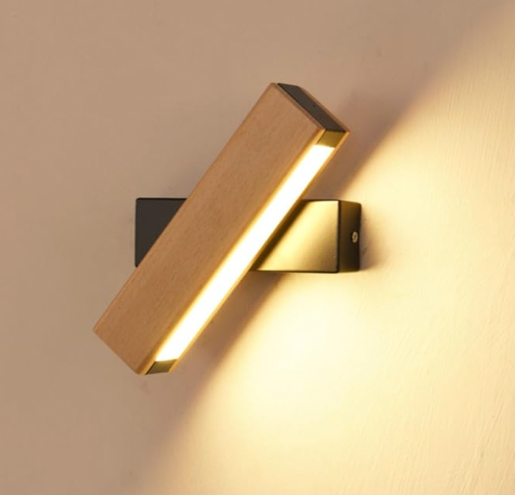 Nahaufnahme der schräg gedrehten Holz-Wandleuchte mit schwarzer Halterung und leuchtendem LED-Streifen.