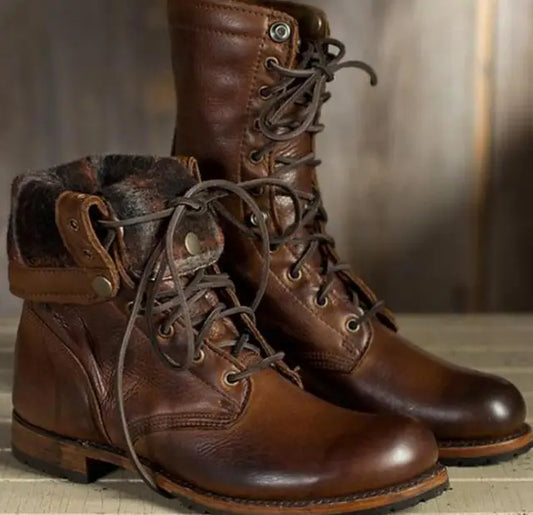 Zwei braune Lederstiefel mit Schnürung, der linke Schaft ist umgeklappt und zeigt das weiche, gemusterte Innenfutter. 1