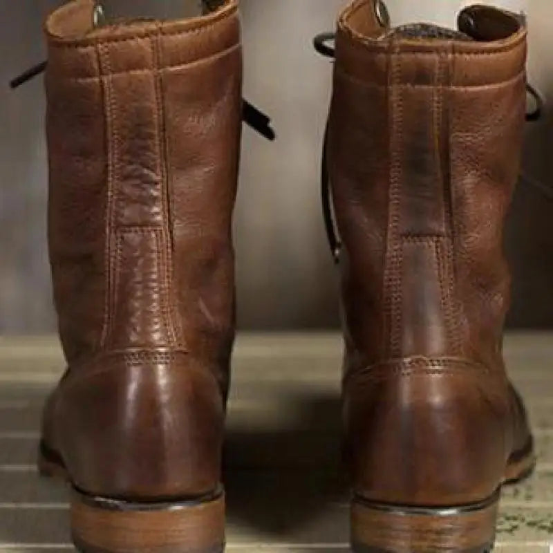 Rückansicht der braunen Lederstiefel mit Ziernähten am Schaft und flachem Absatz.