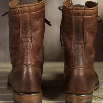 Rückansicht der braunen Lederstiefel mit Ziernähten am Schaft und flachem Absatz.