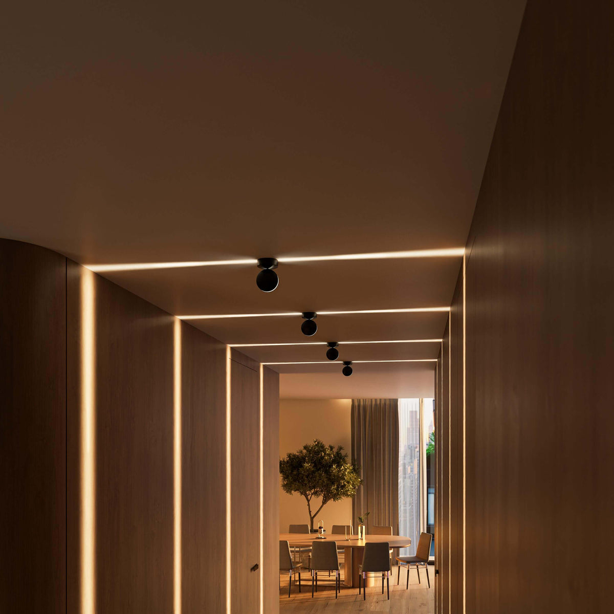 Holzverkleideter Flur mit schwarzen Deckenleuchten, deren waagerechte Lichtstreifen die Decke und die senkrechten Lichtlinien an den Wänden betonen. 14