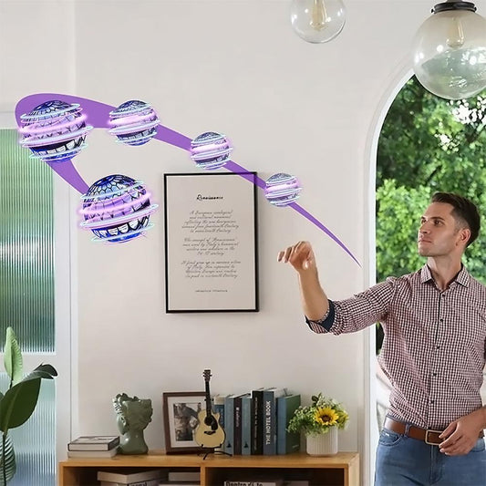 Mann wirft lila LED-Flugspielzeug im Wohnzimmer, moderne Unterhaltung, Indoor-Drohne.