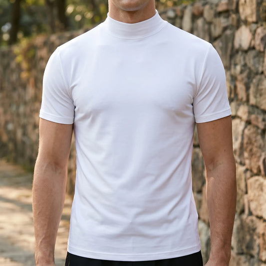 Weißes Kurzarmshirt mit Stehkragen, getragen von einem Mann vor einer Natursteinmauer im Freien, Frontansicht ohne Gesicht. 1
