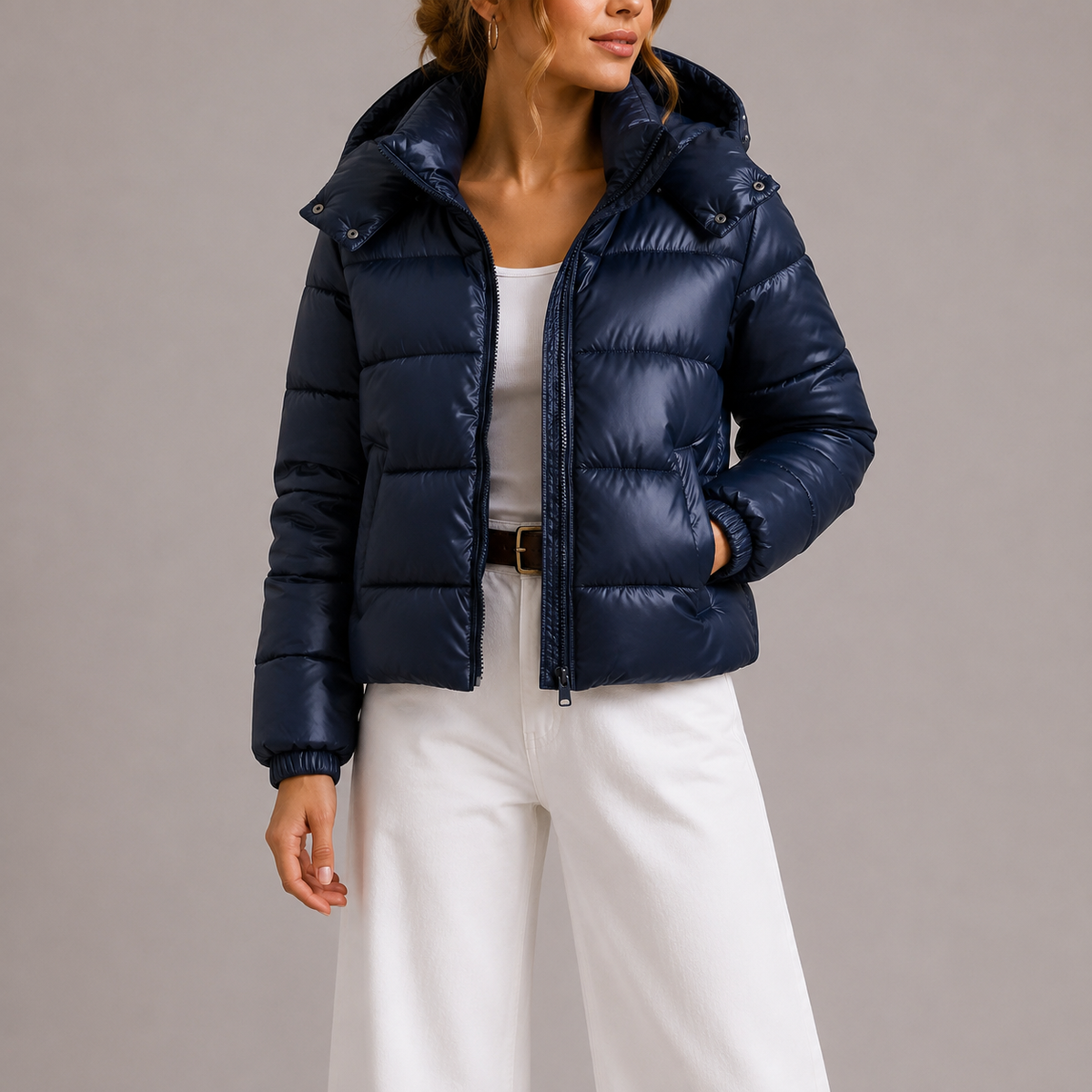 Frontansicht: Model trägt die marineblaue Steppjacke offen über weißem Top und weiter weißer Hose 2